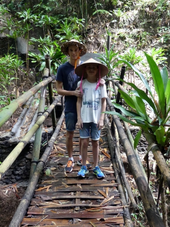 Sur un pont en bambous avec le chapeau traditionne